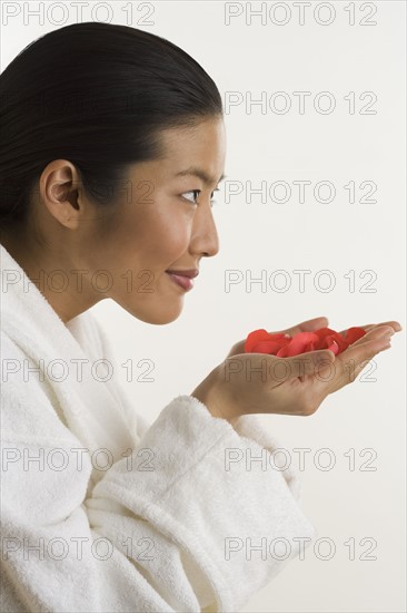 Woman smelling rose petals.