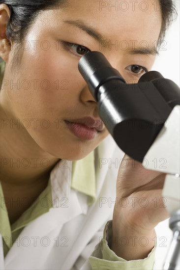 Scientist looking through microscope.