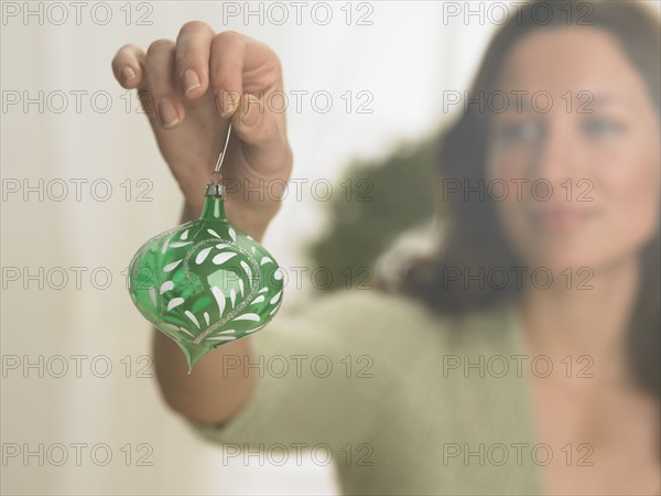 Woman holding Christmas ornament.