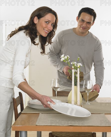Couple setting the table.