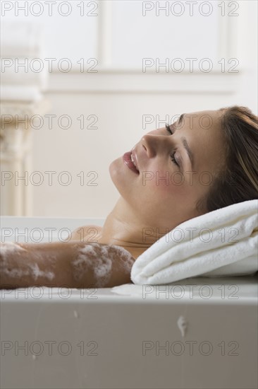 Woman relaxing in bathtub.