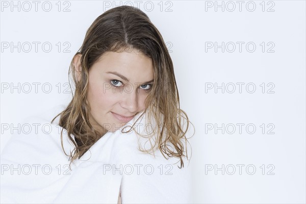 Woman with wet hair wrapped in towel.