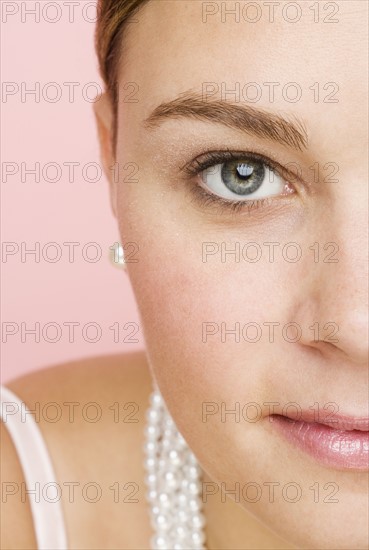 Close up of woman wearing pearls.