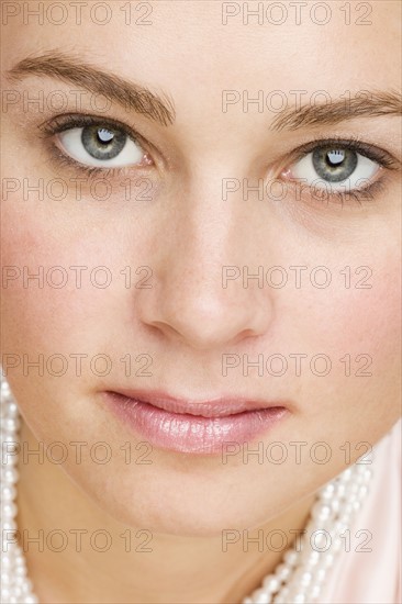 Close up of woman wearing pearls.