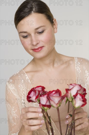 Close up of woman arranging stemmed roses.