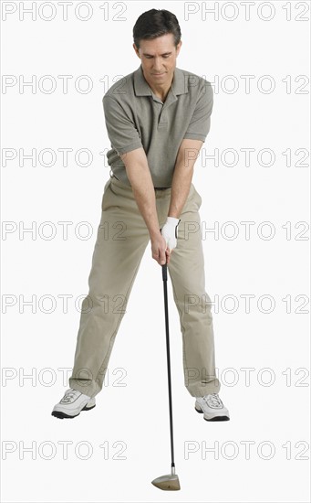 Studio shot of man playing golf.