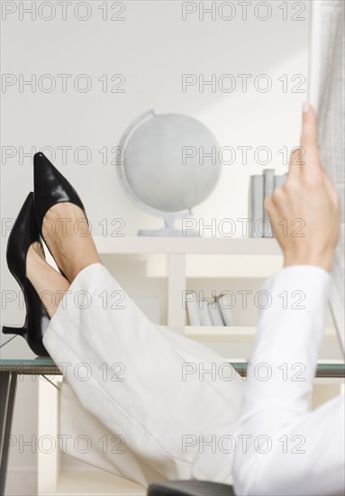 Woman reading newspaper business page.