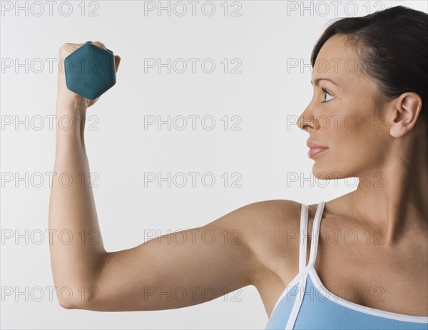 Profile of woman with hand weight.