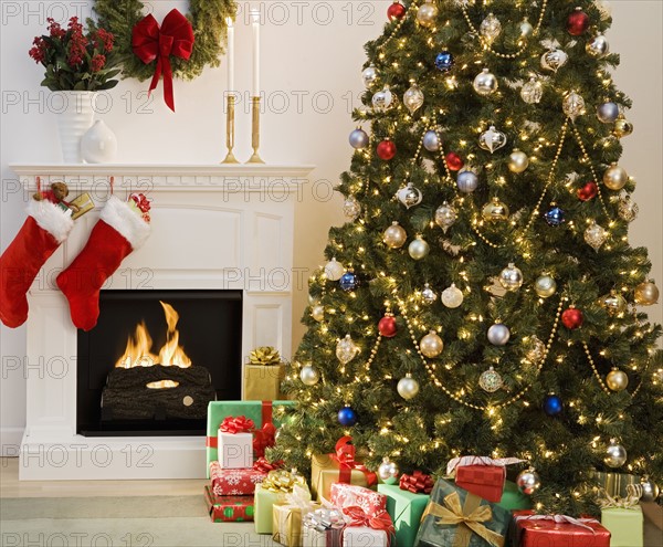 Christmas tree with presents and fireplace with stockings.