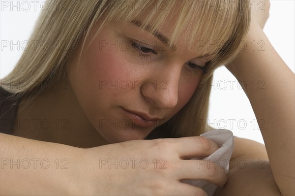 Sad woman holding handkerchief.