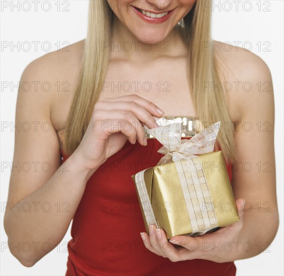 Studio shot of woman opening gift.