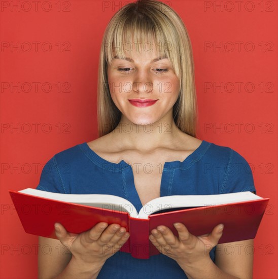 Studio shot of woman reading a book.