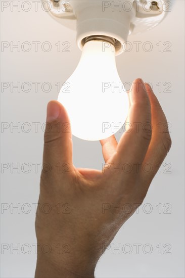 Close up of lightbulb being screwed in .