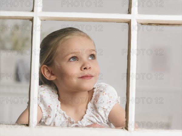 Young girl looking out window.
