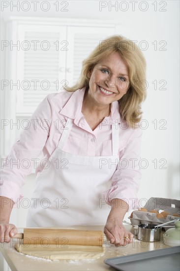 Senior woman rolling dough.