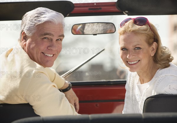 Senior couple sitting in jeep.