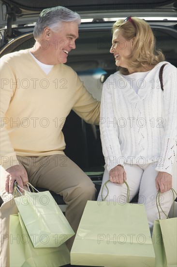 Senior couple with shopping in bags.