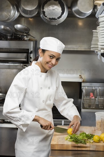 Female chef in restaurant kitchen.