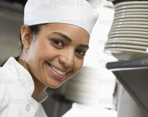 Female chef in restaurant kitchen.