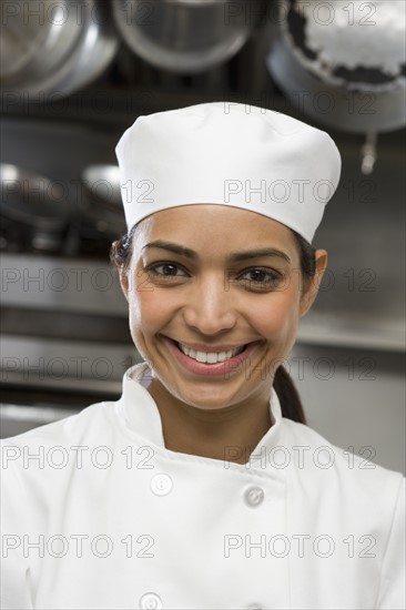 Female chef in restaurant kitchen.