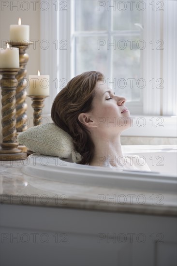 Woman relaxing in bathtub.