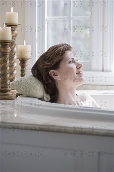 Woman relaxing in bathtub.