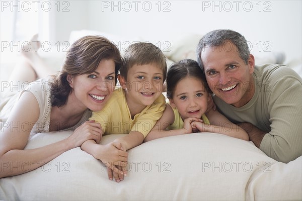 Family lying on bed.