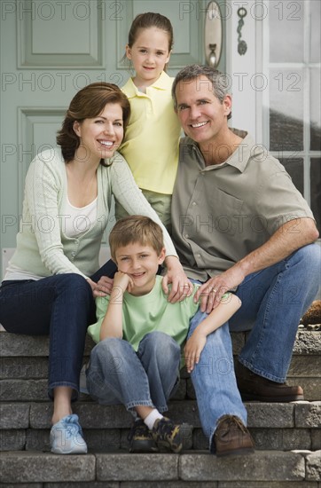 Family sitting on front steps.