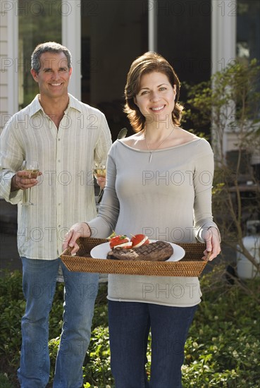 Couple carrying food and drink outdoors.