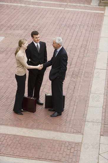 Three business people meeting outdoors.