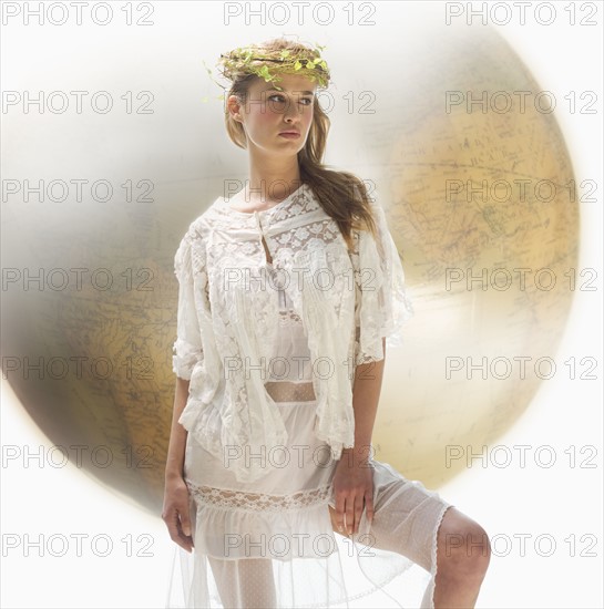 Young female with large globe in background.