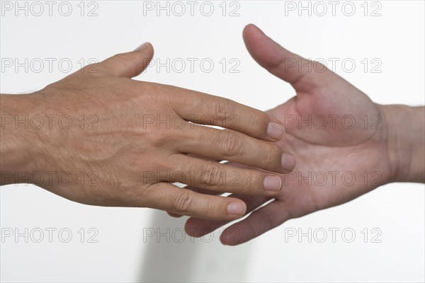 Closeup of men about to shake hands.