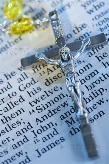 Close up of crucifix with rosary on Bible.