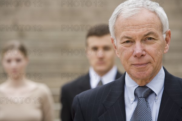 Portrait of businessman with colleagues in background.