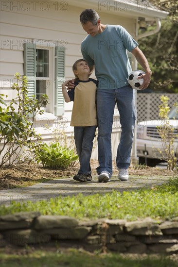 Father and young son with soccer ball.