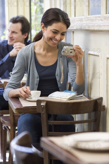 Woman looking at digital camera in restaurant.