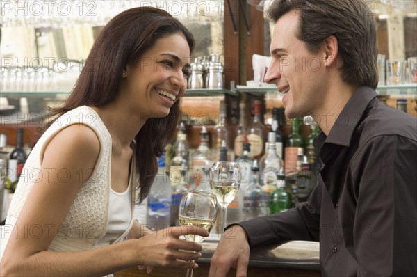 Couple talking at bar.