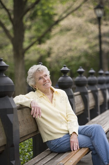 Portrait of woman sitting on park bench.