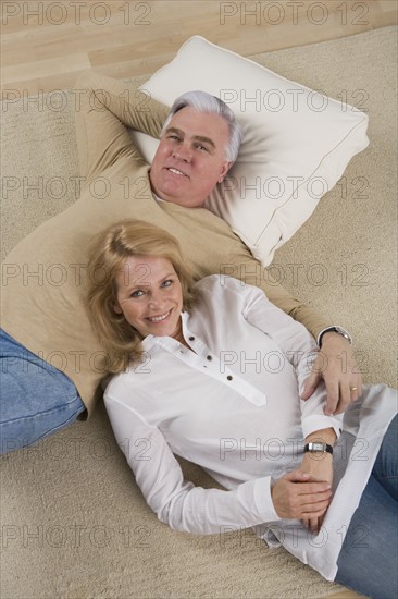 Senior couple lying on floor.