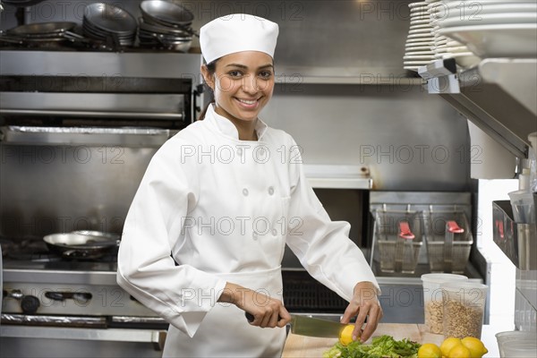 Female chef in restaurant kitchen.