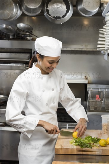 Female chef in restaurant kitchen.