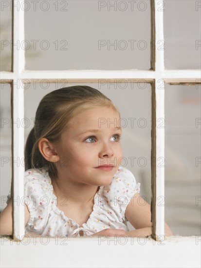 Young girl looking out window.