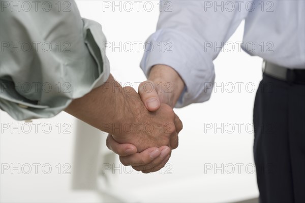 Men in shirtsleeves shaking hands.