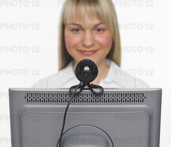 Studio shot of woman using webcam.