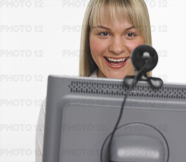 Studio shot of woman using webcam.