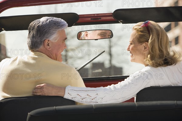 Senior couple sitting in jeep.