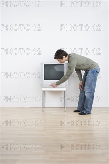 Man turning on television.