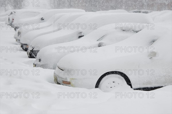 Cars buried in snow.