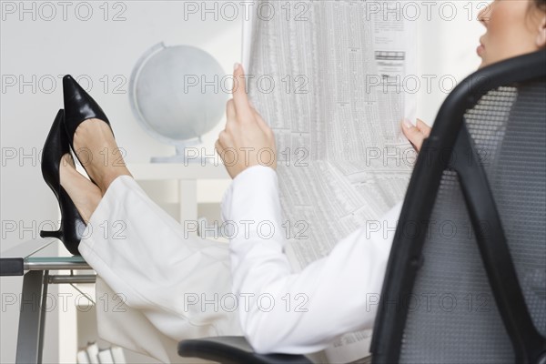 Businesswoman reading business page.