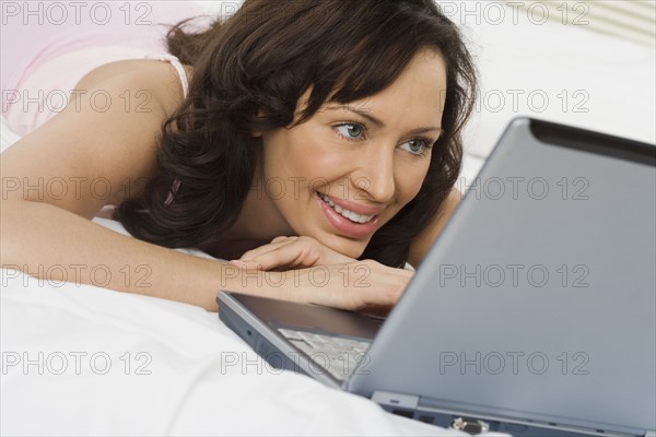 Woman in bed with laptop computer.